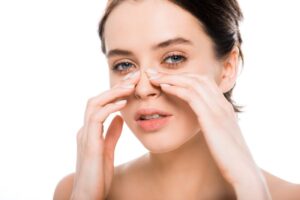 Woman touching her nose, wearing thoughtful expression